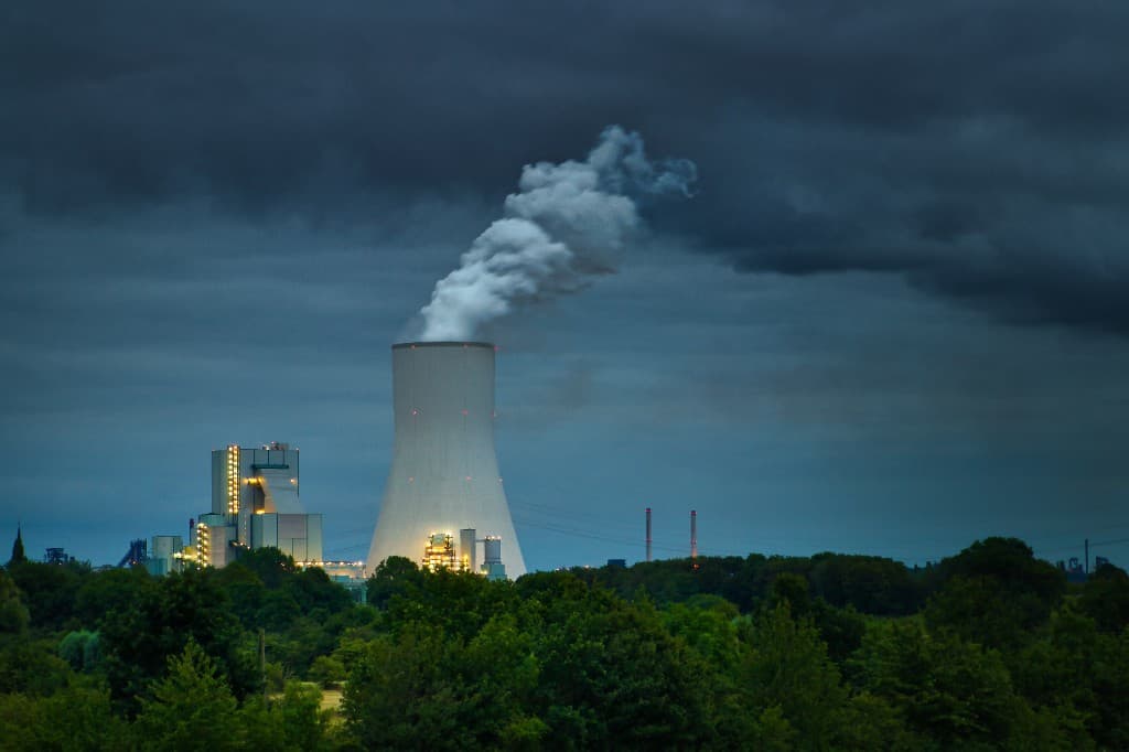 Cooling tower and power plant at dusk — acute physical climate risk